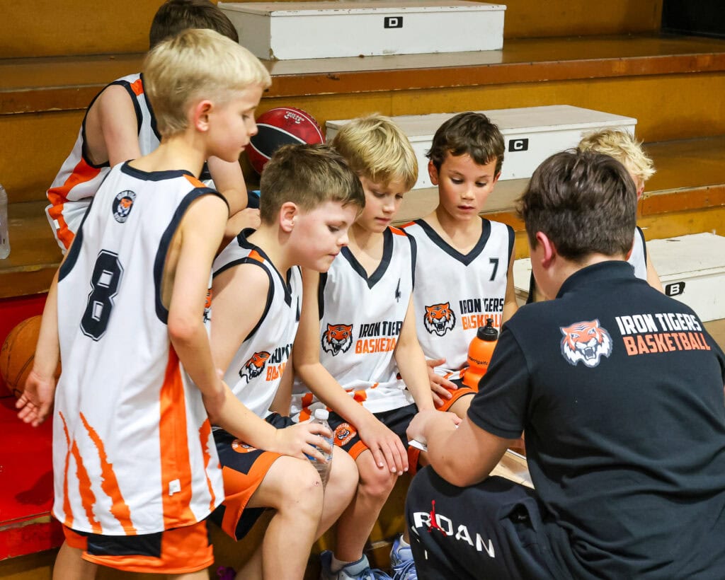 Iron Tigers Coach leading team huddle with junior iron tigers players